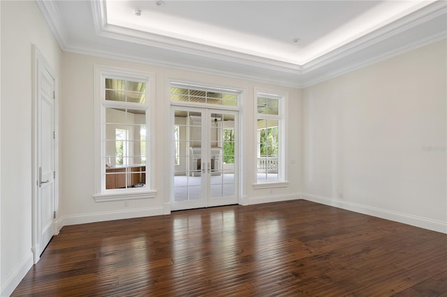 spare room featuring ornamental molding, dark hardwood / wood-style flooring, french doors, and a raised ceiling