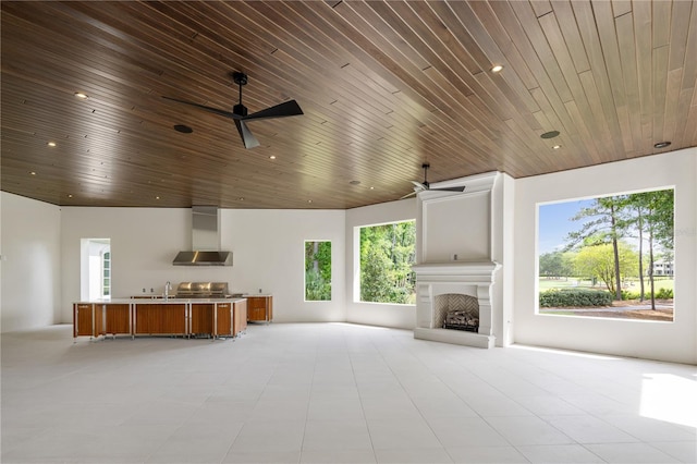 unfurnished living room with wooden ceiling, ceiling fan, and tile floors