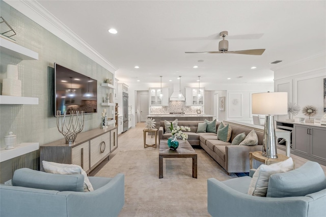 living room with ornamental molding and ceiling fan