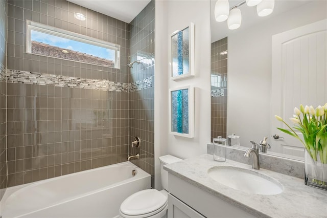 full bathroom with tiled shower / bath, toilet, and vanity with extensive cabinet space