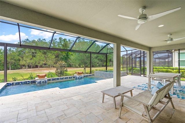 view of pool featuring glass enclosure, an in ground hot tub, ceiling fan, and a patio area