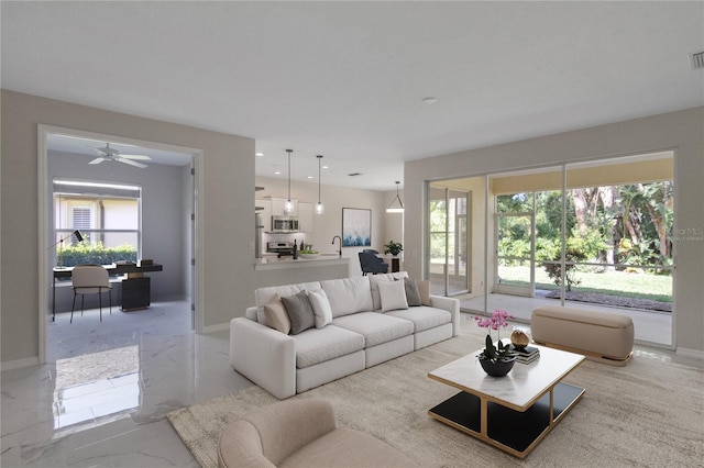 living room featuring ceiling fan and a healthy amount of sunlight