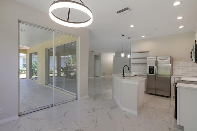 kitchen with decorative light fixtures, backsplash, stainless steel appliances, sink, and light tile floors