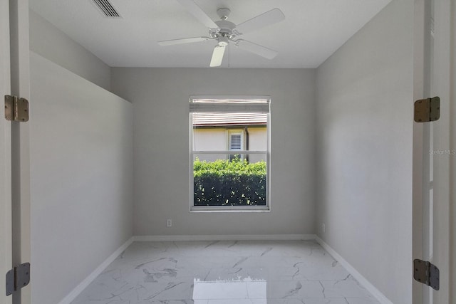 tiled empty room featuring ceiling fan