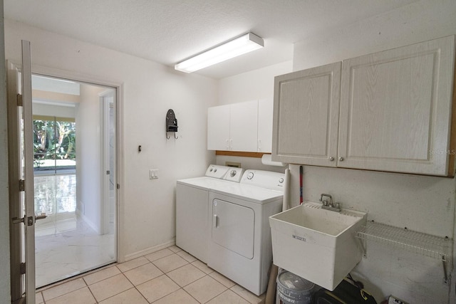 laundry area featuring light tile flooring, hookup for a washing machine, washing machine and clothes dryer, sink, and cabinets