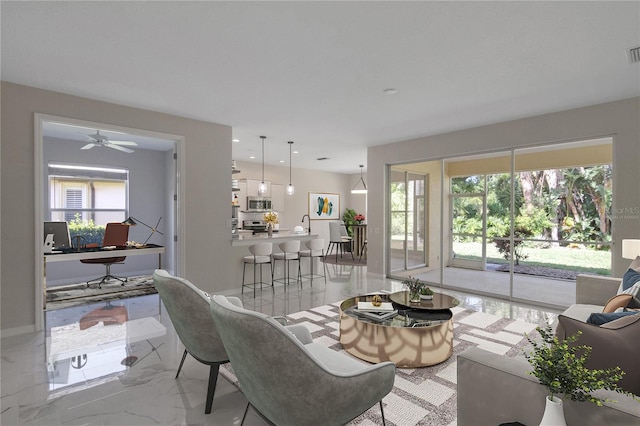 tiled living room with plenty of natural light and ceiling fan