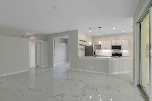 kitchen with decorative light fixtures, appliances with stainless steel finishes, backsplash, white cabinets, and sink