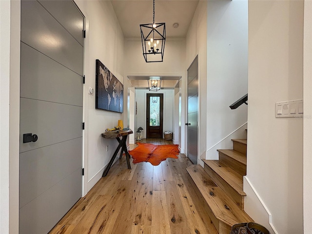 foyer with light hardwood / wood-style flooring and a notable chandelier