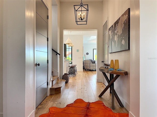 foyer entrance featuring a chandelier and light hardwood / wood-style floors