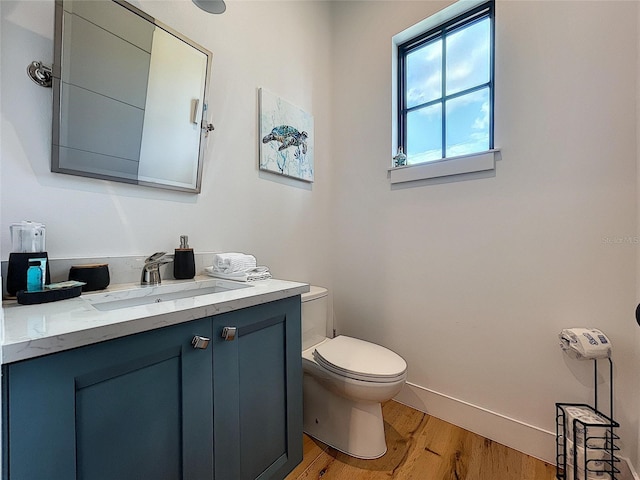 bathroom with hardwood / wood-style floors, vanity, and toilet