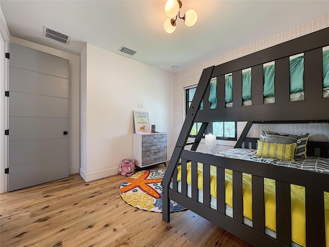 bedroom with an inviting chandelier and wood-type flooring