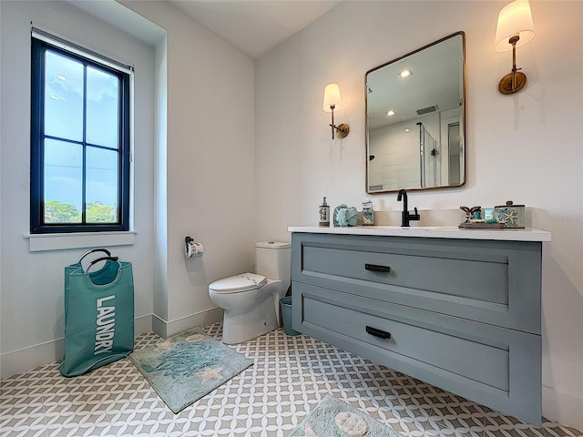 bathroom with toilet, tile floors, and vanity