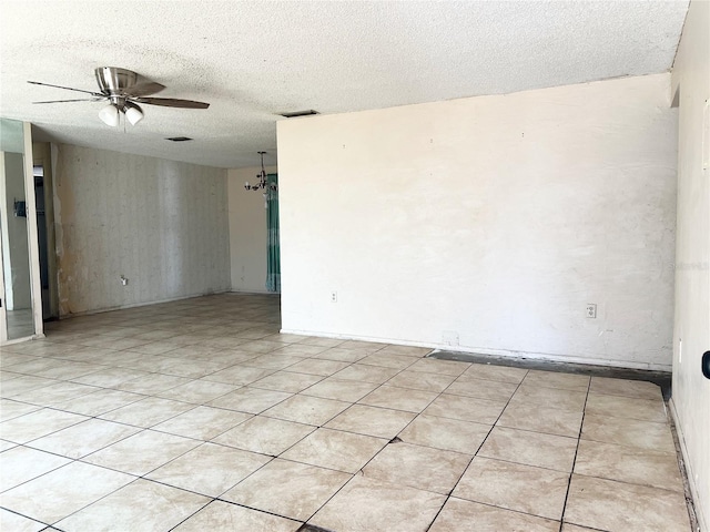 tiled empty room with a textured ceiling and ceiling fan