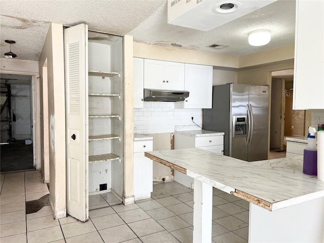 kitchen with white cabinetry, stainless steel fridge with ice dispenser, a textured ceiling, tasteful backsplash, and light tile flooring