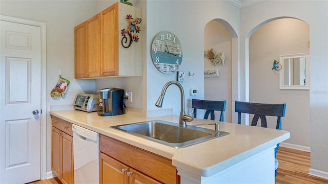 kitchen with dishwasher, sink, kitchen peninsula, crown molding, and light wood-type flooring