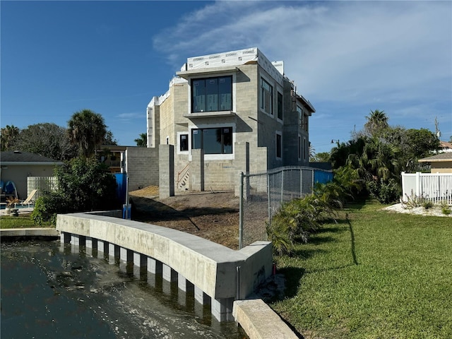 rear view of house featuring a lawn and a water view