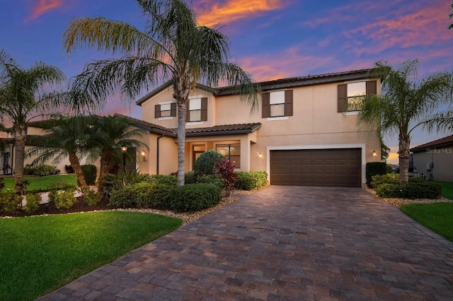 mediterranean / spanish-style house featuring a garage and a lawn