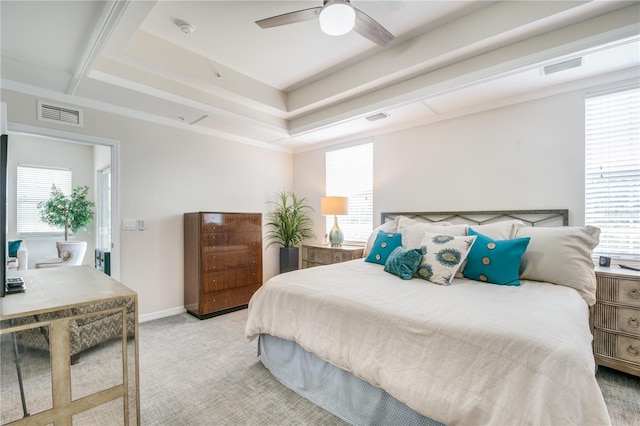 carpeted bedroom with ceiling fan and a raised ceiling