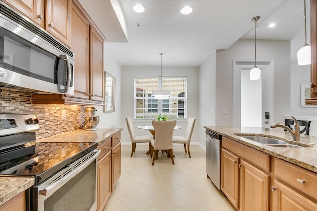 kitchen with light stone countertops, appliances with stainless steel finishes, backsplash, pendant lighting, and light tile floors