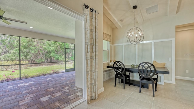 dining space featuring ceiling fan with notable chandelier, lofted ceiling, light tile flooring, and a textured ceiling