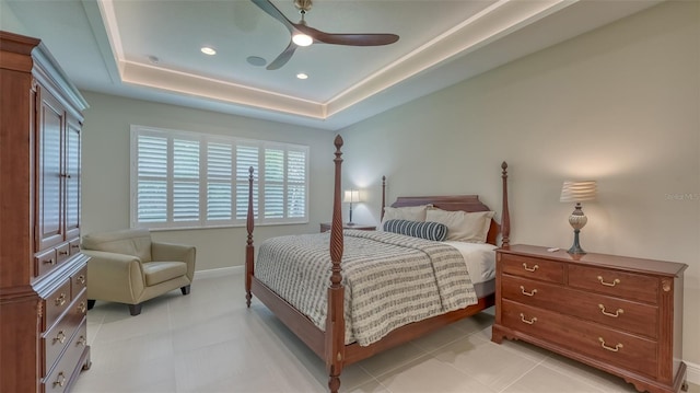 tiled bedroom with ceiling fan and a raised ceiling