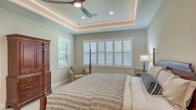 bedroom with ceiling fan and a tray ceiling