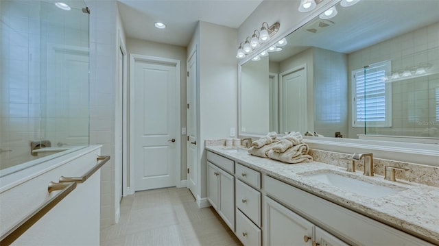 bathroom featuring tile flooring, vanity with extensive cabinet space, and double sink