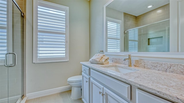 bathroom with a healthy amount of sunlight, toilet, tile flooring, and vanity