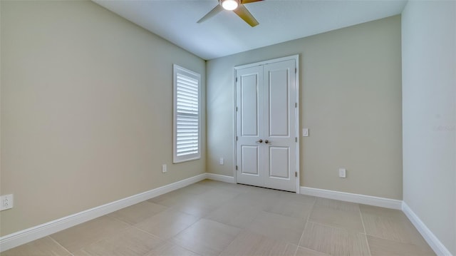 tiled spare room with ceiling fan