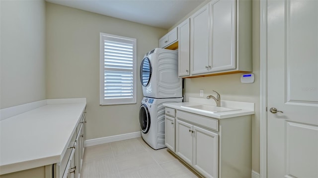 clothes washing area featuring cabinets, sink, light tile floors, and stacked washer / drying machine