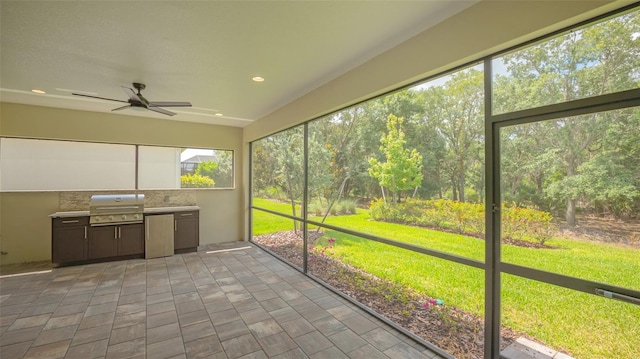 unfurnished sunroom featuring ceiling fan