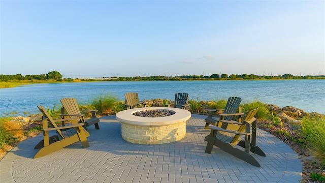 view of patio with a water view and a fire pit