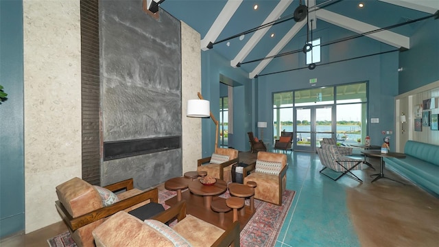 interior space featuring a water view, high vaulted ceiling, a high end fireplace, beam ceiling, and concrete flooring