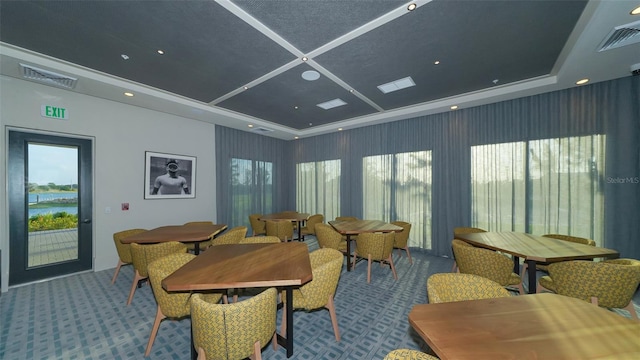 dining room with a healthy amount of sunlight, carpet, and a water view