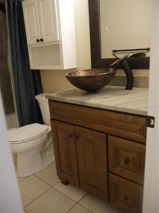 bathroom with toilet, vanity, and tile patterned floors