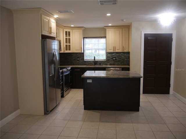 kitchen with sink, light tile patterned floors, tasteful backsplash, a kitchen island, and stainless steel appliances