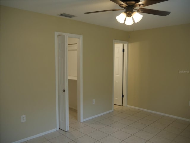 unfurnished bedroom featuring ceiling fan, light tile patterned floors, and a closet