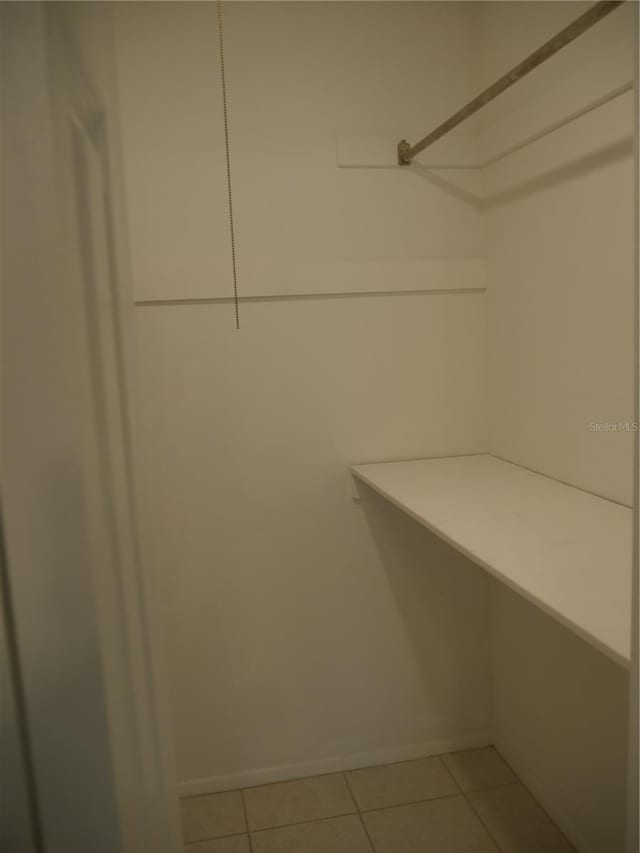 walk in closet with light tile patterned floors