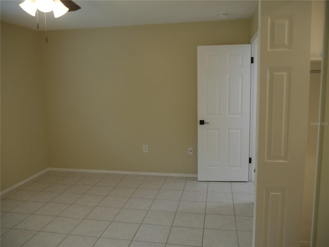 tiled spare room featuring ceiling fan