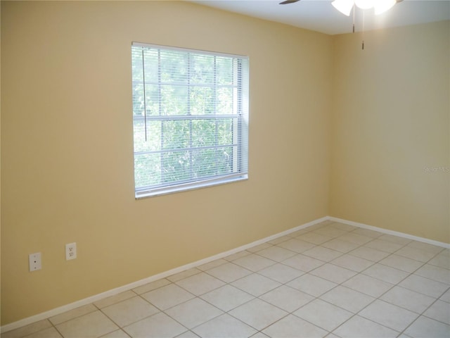 unfurnished room featuring ceiling fan, light tile patterned floors, and a healthy amount of sunlight