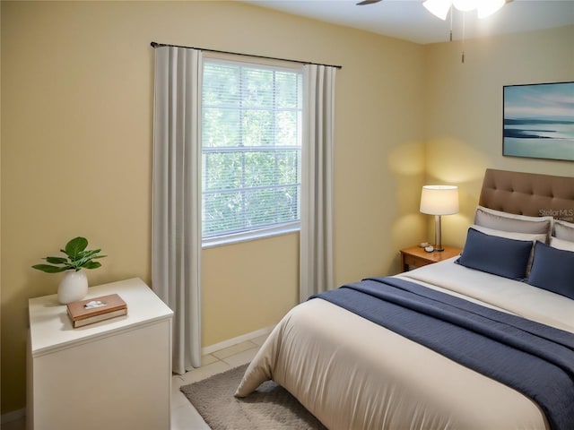 bedroom with ceiling fan and light tile patterned flooring