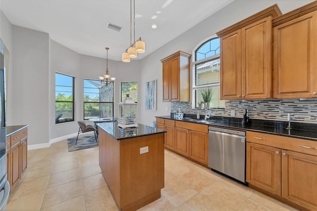 kitchen with a center island, pendant lighting, backsplash, light tile floors, and stainless steel dishwasher