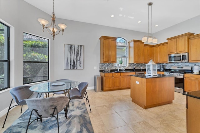 kitchen with a center island, light tile flooring, backsplash, decorative light fixtures, and stainless steel appliances