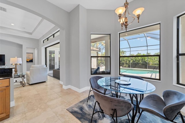 dining area featuring light tile flooring, french doors, a healthy amount of sunlight, and an inviting chandelier