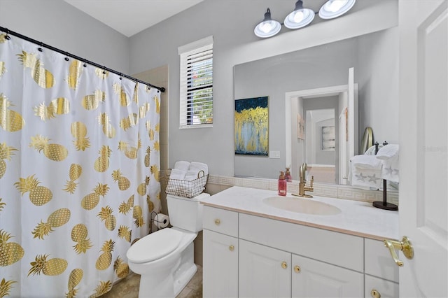 bathroom featuring vanity with extensive cabinet space, toilet, and tile flooring