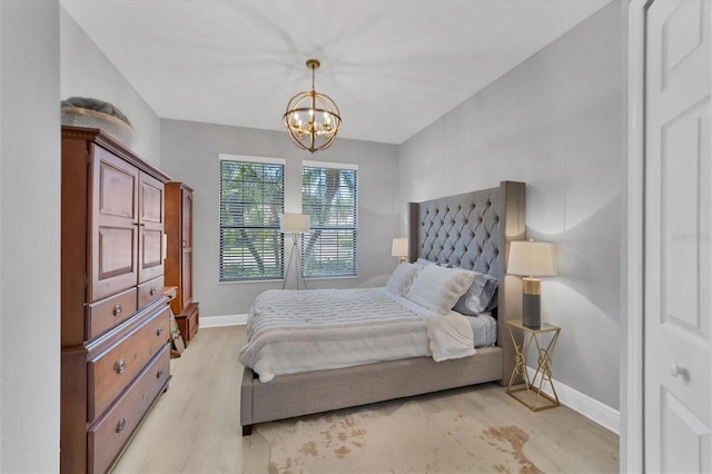 bedroom with an inviting chandelier and light wood-type flooring