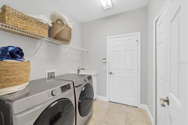 clothes washing area featuring sink, hookup for a washing machine, light tile floors, and washer and dryer