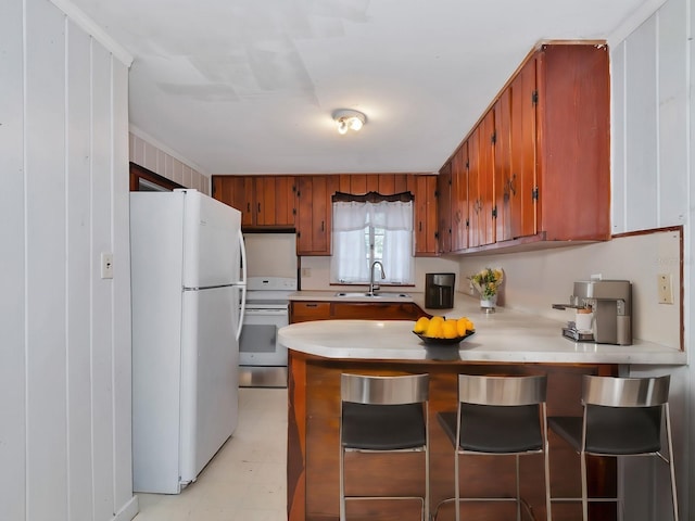 kitchen featuring sink, white appliances, and kitchen peninsula