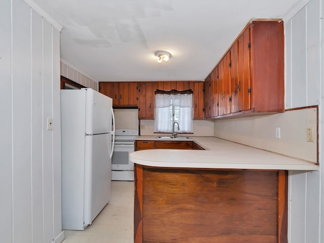 kitchen featuring sink, white appliances, and kitchen peninsula