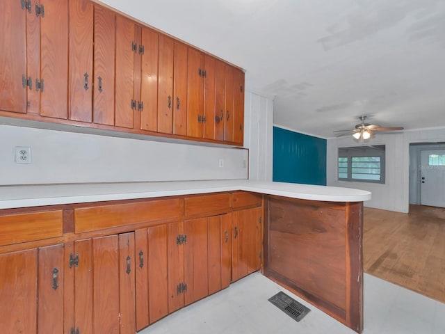 kitchen featuring light hardwood / wood-style flooring, ceiling fan, and kitchen peninsula